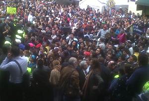 Reunidas en la entrada del recinto, decenas de personas corean porras para algunos diputados