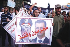 Un palestino muestra un cartel con los rostros del lder sirio Bashar al-Assad (der.) y del jefe mil