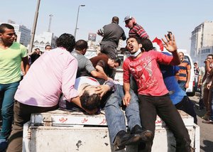 Seguidores del depuesto presidente egipcio Mohamed Mursi ayudan a los lesionados en los enfrentamien