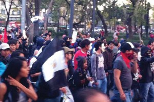 Aspecto de un sector de la movilizaic�n en el que manifestantes marchaban con el rostro cubierto