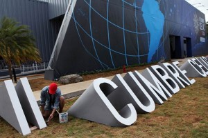 Un trabajador pinta una parte de un letrero de la II Cumbre de la Comunidad de Estados Latinoamerica