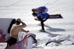 Un hombre sin playera observa a los atletas