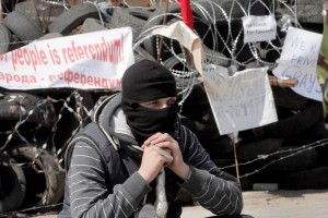 Un activista prorruso enmascarado resguarda una barricada en el edificio de la administracin region