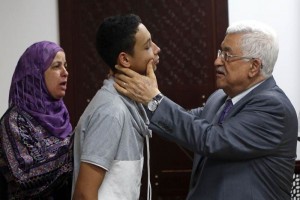 El lder de la autoridad palestina revisa el rostro de un joven palestino golpeado hace unos das po