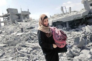 Una palestina carga sus pertenencias y camina a travs de los escombros que dejaron los ataques del 