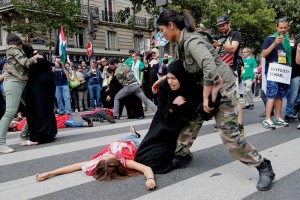 Manifestantes escenifican en Pars una escena durante una protesta contra las operaciones militares 
