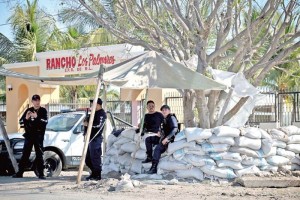 Elementos de la polica ministerial y de la Procuradura de Michoacn vigilan las entradas al poblad