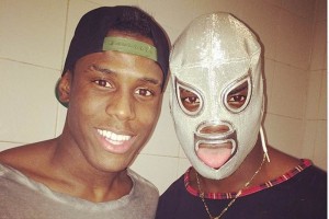 El delantero del Liverpool (derecha) posa con la m�scara del Santo mientras su hermano lo acompa�a