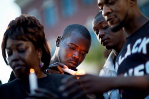 Un joven afroamericano enciende una vela durante una marcha en North Charleston, Carolina del Sur, c