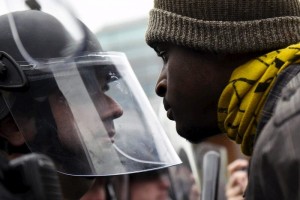 Un manifestante y un polica se encaran durante las protestas de esta tarde en Baltimore